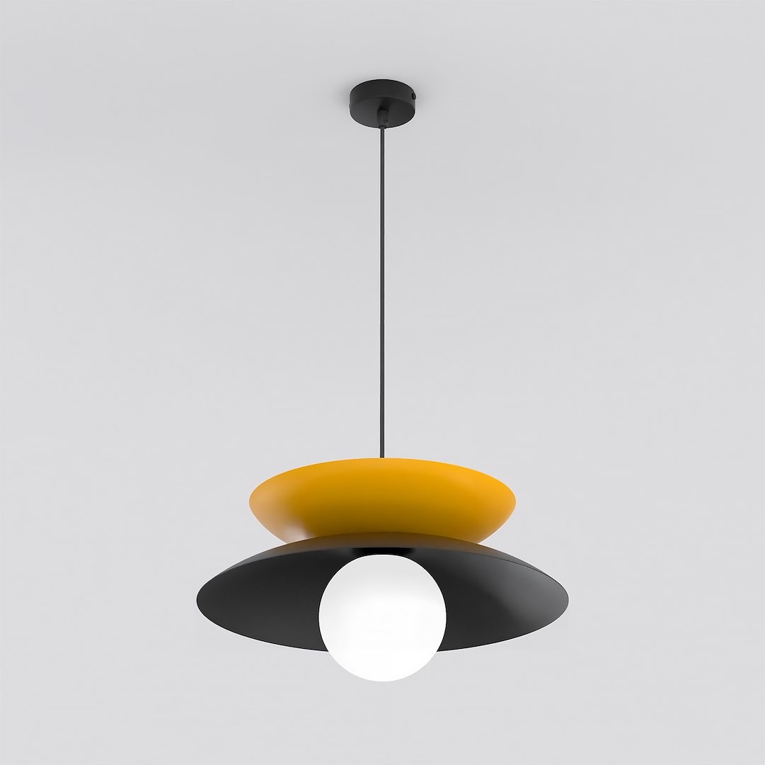 Lampa wisząca Nagoya 1xG9 w kolorze czarnym i pomarańczowym, z okrągłą, białą kulą na dole. Ujęcie frontalne, lampa zawieszona na cienkim przewodzie, z dwiema okrągłymi, teksturowanymi osłonami w kształcie talerzy. Tło jasne.