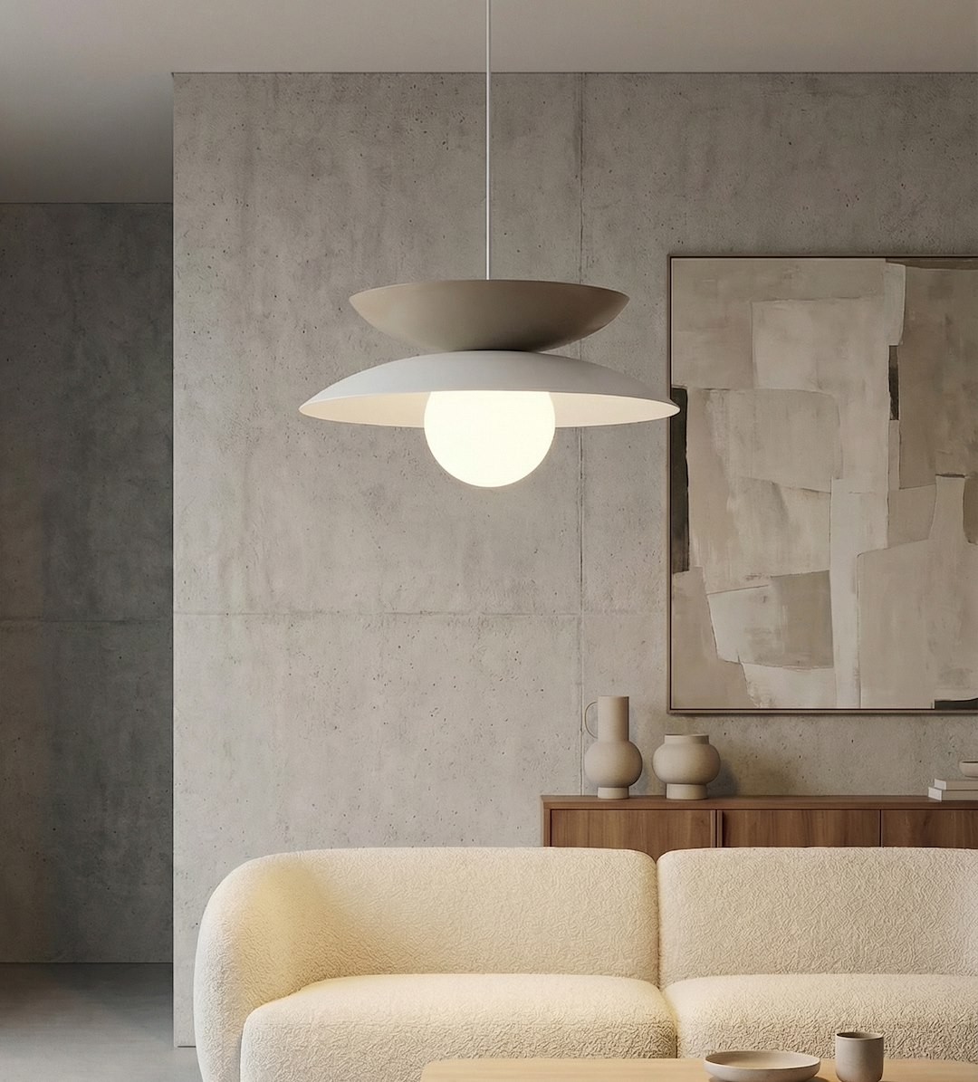 Lampa wisząca Nagoya 1xG9 w kolorze białym i mokka, z okrągłym kloszem. Ujęcie frontalne, zawieszona nad jasną sofą w nowoczesnym wnętrzu, z betonową ścianą w tle i minimalistycznymi dekoracjami.