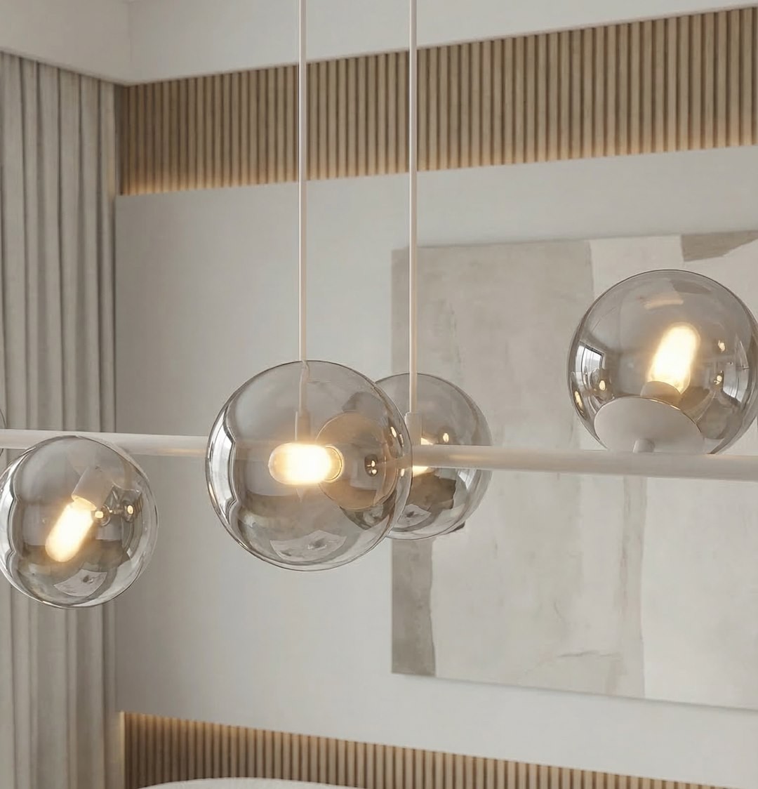 Lampa wisząca Magnus z 8 źródłami światła E14, w kolorze szarym i grafitowym. Posiada przezroczyste, kuliste klosze, zawieszone na białej konstrukcji. Widoczna w nowoczesnym wnętrzu z drewnianymi akcentami.