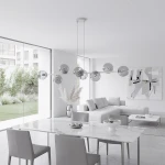 Lampa wisząca Magnus w kolorze szarym i grafitowym, z ośmioma miejscami na żarówki E14. Zawieszona nad stołem w nowoczesnym wnętrzu, z metalowymi kulistymi kloszami i minimalistycznym designem, w otoczeniu jasnych mebli i dużych okien.