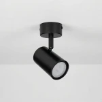 Lampa sufitowa spot GU10 w kolorze czarnym, zamontowana na okrągłej podstawie. Cylindryczny kształt oprawy skierowany lekko w dół, z widocznym źródłem światła LED. Prosty, nowoczesny design na jednolitym tle.