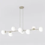 Lampa wisząca Magnus z osiemnastoma źródłami światła E14, w kolorze mokka i białym. Posiada prostą, poziomą konstrukcję z kulistymi kloszami, zawieszona na dwóch linkach. Tło jest jasne, co podkreśla elegancki design lampy.