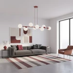 Lampa wisząca Magnus 8xE14 w kolorze burgundowym i białym, z ośmioma okrągłymi kloszami. Zawieszona na czerwonym stelażu, umieszczona w nowoczesnym wnętrzu z szarym sofą i abstrakcyjnymi obrazami w tle.