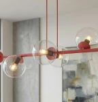 Lampa wisząca Magnus 8xE14 w kolorze burgundowym z przezroczystymi kloszami. Ułożona na prostym, poziomym stelażu, z widocznymi żarówkami. Tło w jasnych odcieniach, z nieostrym obrazem w stylu nowoczesnym.