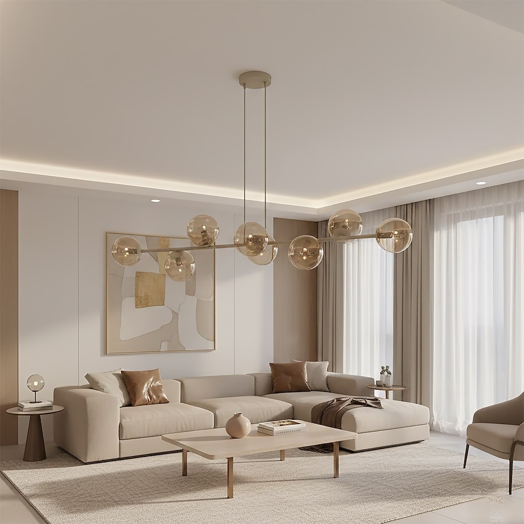 Lampa wisząca Magnus z 8 kloszami E14 w kolorze mokka i bursztynowym, zawieszona na cienkich linkach, umieszczona w nowoczesnym wnętrzu z jasnym tłem, obok kanapy i stołu. Klosze mają okrągły kształt i przezroczystą fakturę.