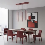Lampa wisząca Selter 6xG9 w kolorze burgundowym, z sześcioma długimi, cylindrycznymi źródłami światła zwisającymi z prostokątnej podstawy. Umieszczona nad drewnianym stołem w nowoczesnej jadalni z burgundowymi krzesłami. Tło w jasnym odcieniu szarości.