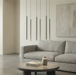 Lampa wisząca Selter 6xG9 w kolorze szarym, składająca się z sześciu prostokątnych, wiszących elementów, umieszczona nad okrągłym stołem. W tle szara tapicerka sofy i minimalistyczne wnętrze.