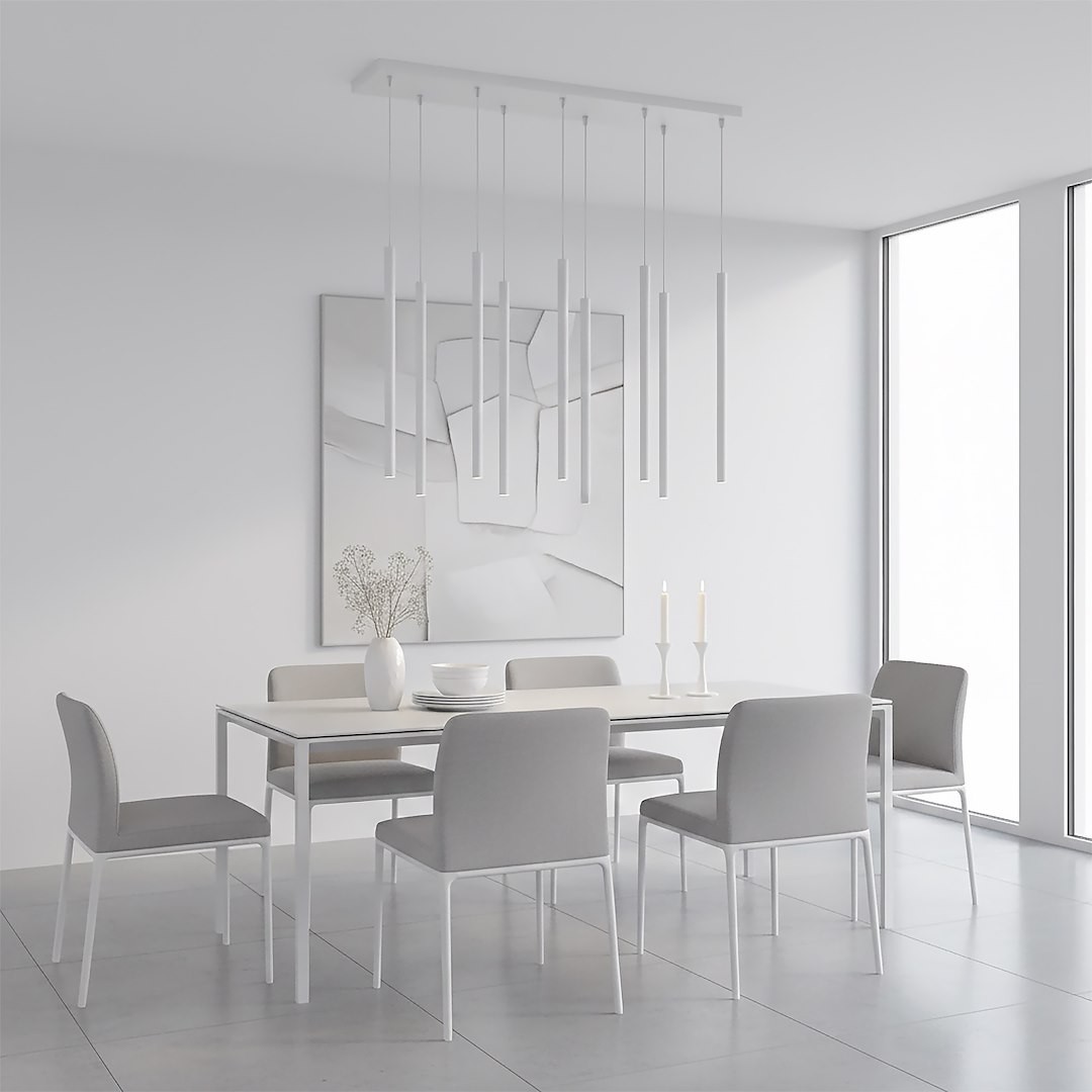 Lampa wisząca Selter 9xG9 w kolorze szarym, składająca się z długich, smukłych kloszy. Zawieszona na prostokątnej podstawie, w nowoczesnej aranżacji jadalni z białym stołem i szarymi krzesłami. Jasne, minimalistyczne tło.