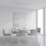 Lampa wisząca Selter 9xG9 w kolorze szarym, składająca się z długich, smukłych kloszy. Zawieszona na prostokątnej podstawie, w nowoczesnej aranżacji jadalni z białym stołem i szarymi krzesłami. Jasne, minimalistyczne tło.