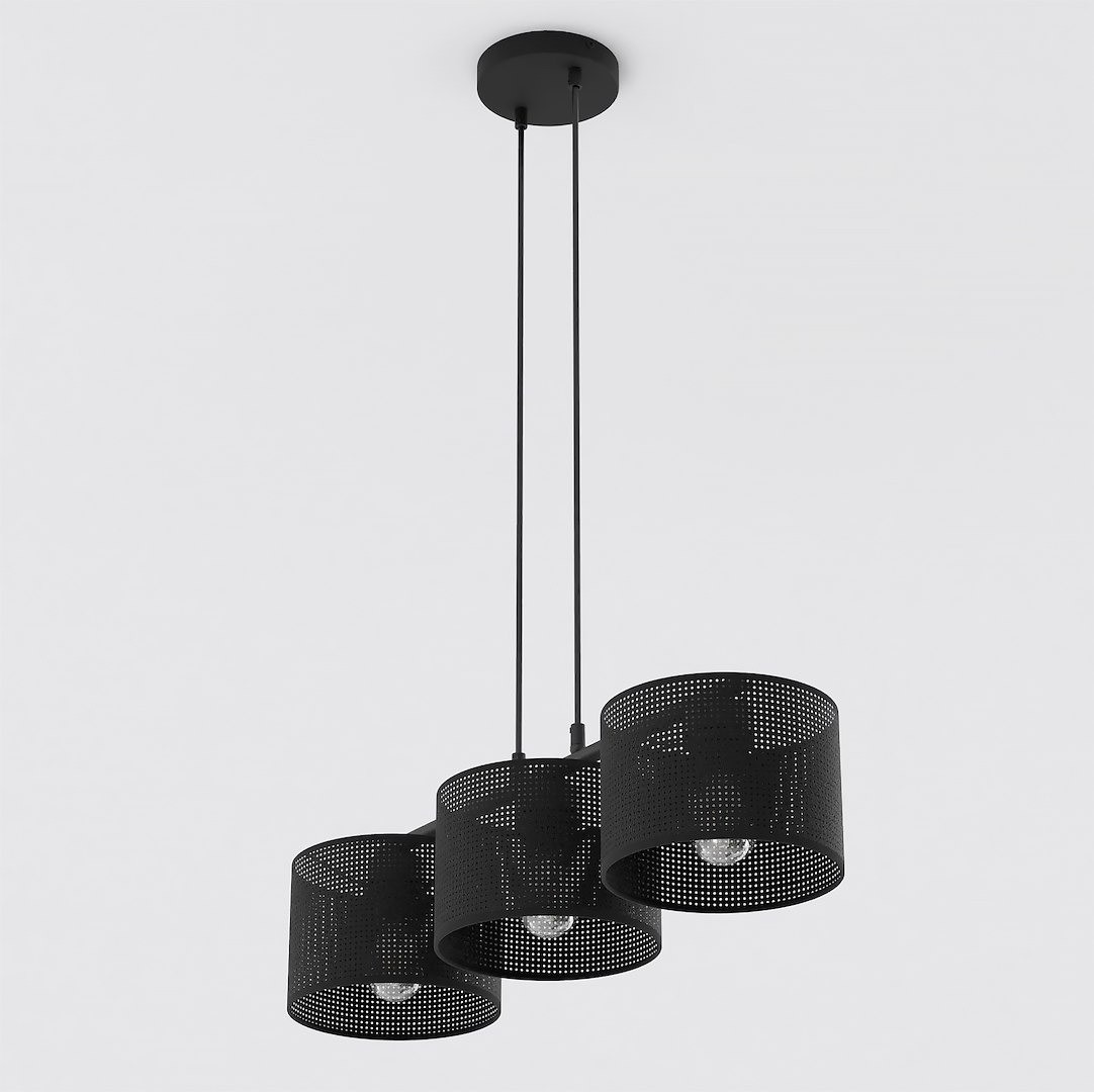 Lampa wisząca Lux w kolorze czarnym z trzema kloszami w kształcie cylindrów, wykonanymi z perforowanego metalu. Zawieszona na dwóch cienkich linkach, z widocznymi żarówkami E27. Proste tło w jasnym kolorze.