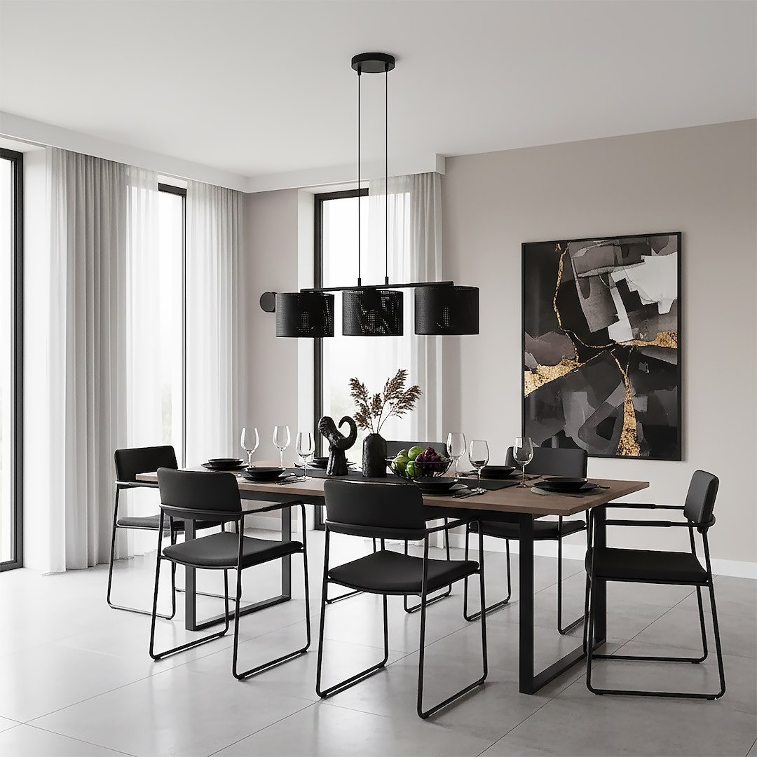 Lampa wisząca Lux 3xE27 w kolorze czarnym, z prostokątnym kloszem, zawieszona na cienkich linkach. Montowana nad drewnianym stołem w nowoczesnej jadalni, otoczona czarnymi krzesłami. Tło w jasnych odcieniach z dużymi oknami i dekoracyjnymi zasłonami.