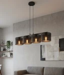 Lampa wisząca Lux w kolorze czarnym, z czterema okrągłymi kloszami z perforowanego metalu, zawieszona na cienkich linkach. Klosze odsłaniają żarówki E27, tworząc nowoczesny wygląd. Zainstalowana w aranżacji z szarymi ścianami i sofą.