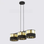 Lampa wisząca Lux 3xE27 w kolorze czarnym i złotym. Posiada trzy okrągłe klosze z perforowanego metalu, zawieszone na długich linkach. Klosze mają górną złotą część, co zapewnia elegancki wygląd. Ujęcie frontalne na jasnym tle.