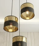 Lampa wisząca Lux 3xE27 w kolorze czarnym i złotym, składająca się z trzech cylindrycznych kloszy z perforowanym wzorem. Klosze zawieszone na cienkich linkach, ukazujące żarówki w środku, na jasnym tle.