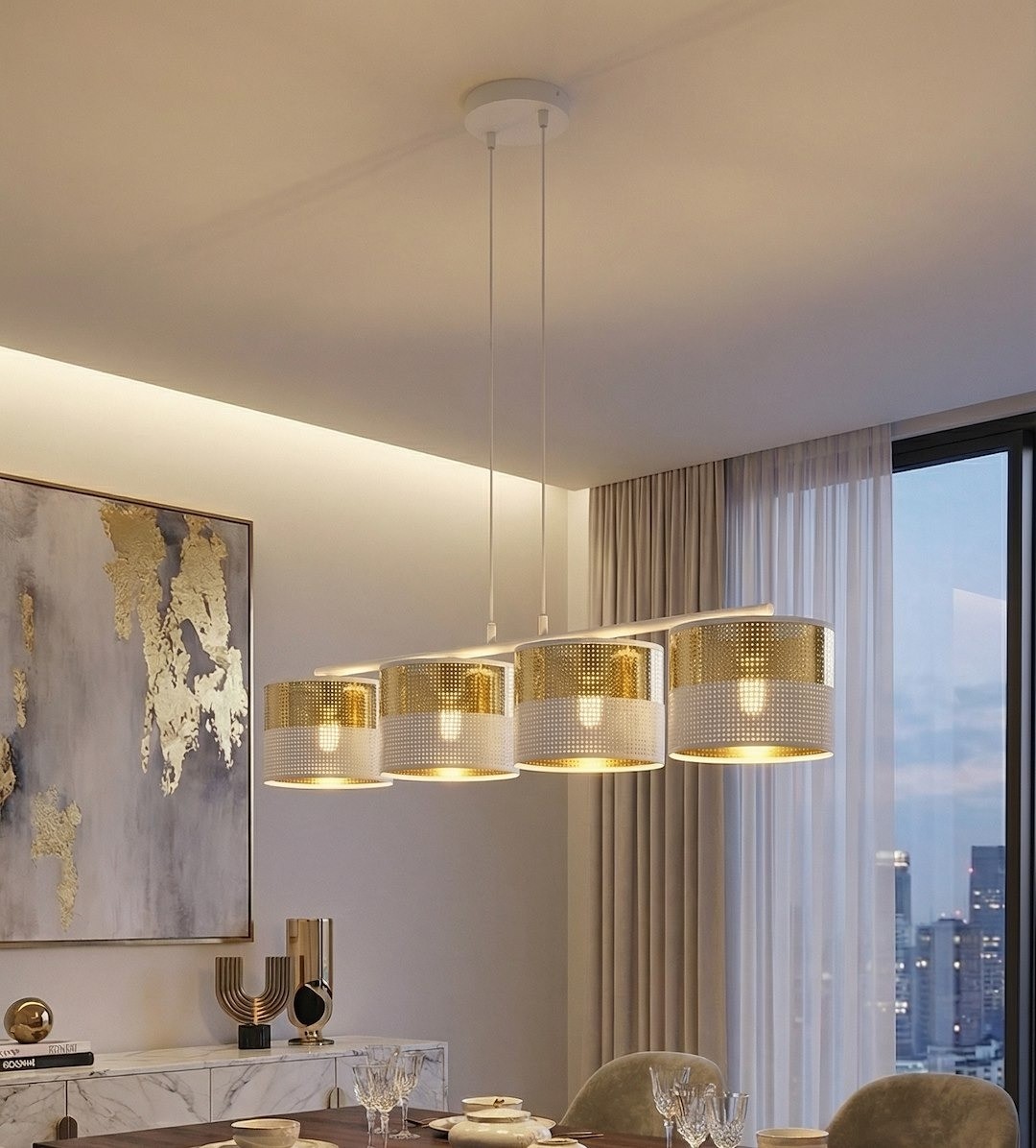 Lampa wisząca Lux 4xE27 w białym kolorze z złotymi elementami, składająca się z czterech okrągłych kloszy. Ujęcie z przodu, z zawieszeniem na białych przewodach. Tło jasne, z dekoracyjną ścianą i zasłonami w tle, tworząc elegancką aranżację.