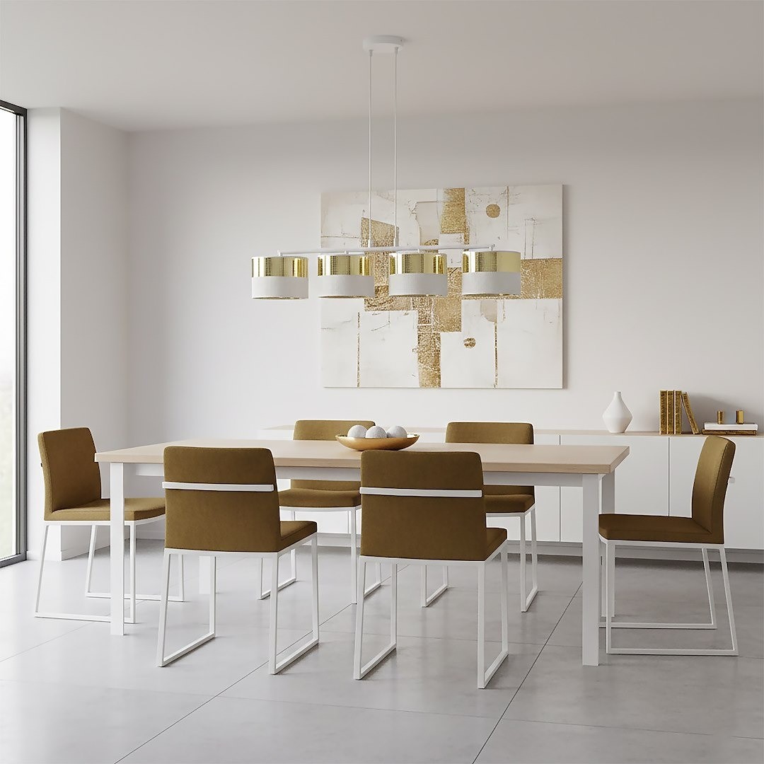 Lampa wisząca Lux 4xE27 w kolorze białym z złotymi detalami, zawieszona nad stołem w jadalni. Produkt ma cztery okrągłe klosze, zawieszone na białych linkach. W tle widoczna minimalistyczna aranżacja z brązowymi krzesłami i prostokątnym stołem.