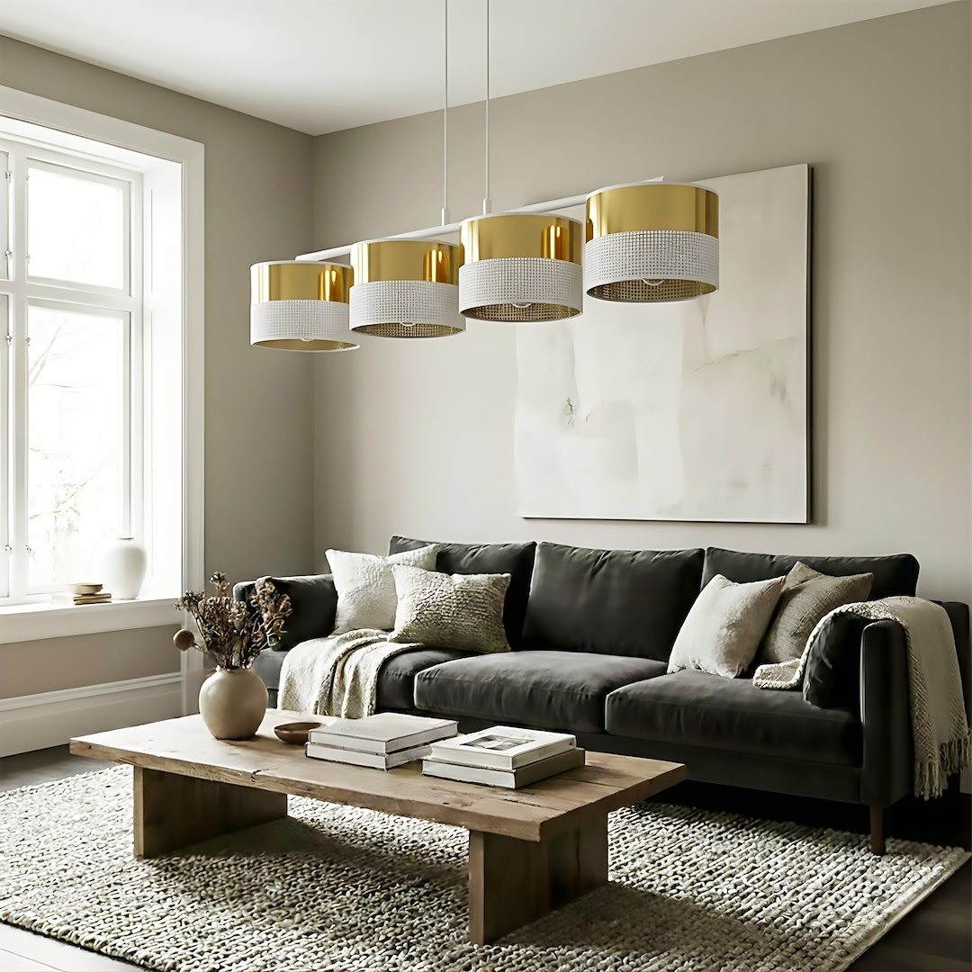 Lampa wisząca Lux 4xE27 w kolorze białym i złotym, z czterema okrągłymi kloszami, zawieszona nad stołem w nowoczesnym wnętrzu. Klosze mają teksturowaną dolną część i błyszczące wykończenie. W tle widoczna kanapa i stół drewniany.