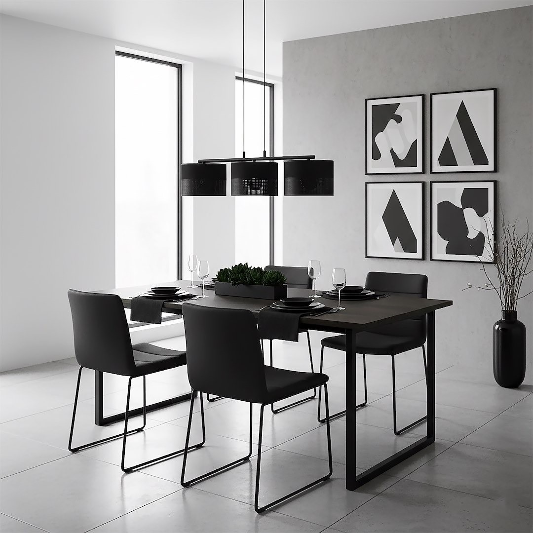 Lampa wisząca Karbon 3xE27 w kolorze czarnym, z okrągłymi kloszami, zawieszona nad ciemnym stołem w nowoczesnej jadalni. W tle widoczne okna oraz minimalistyczne grafiki na ścianie. Meble w odcieniach czerni i szarości.