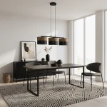 Lampa wisząca Karbon 3xE27 w kolorze czarnym i brązowym z trzema cylindrycznymi kloszami. Umieszczona na długim zwisie, w nowoczesnej aranżacji jadalni z drewnianym stołem i krzesłami, na tle jasnej ściany i dużych okien.