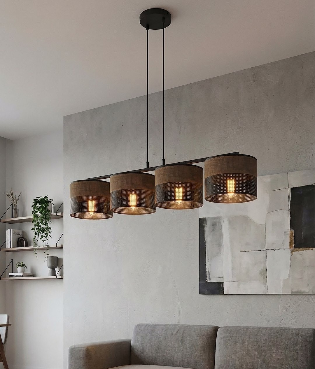 Lampa wisząca Karbon z czterema kloszami E27 w kolorze czarnym i brązowym, zawieszona na prostym, czarnym stelażu. Klosze mają perforowaną strukturę, co pozwala na efektywne rozpraszanie światła. Umieszczona nad szaro-beżową sofą w nowoczesnym wnętrzu.