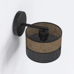 Kinkiet Karbon E27 w kolorze czarnym i brązowym, z okrągłą podstawą i metalowym ramieniem. Abażur w formie cylindrycznej siatki z perforacjami, montowany na ścianie, prezentujący nowoczesny design.