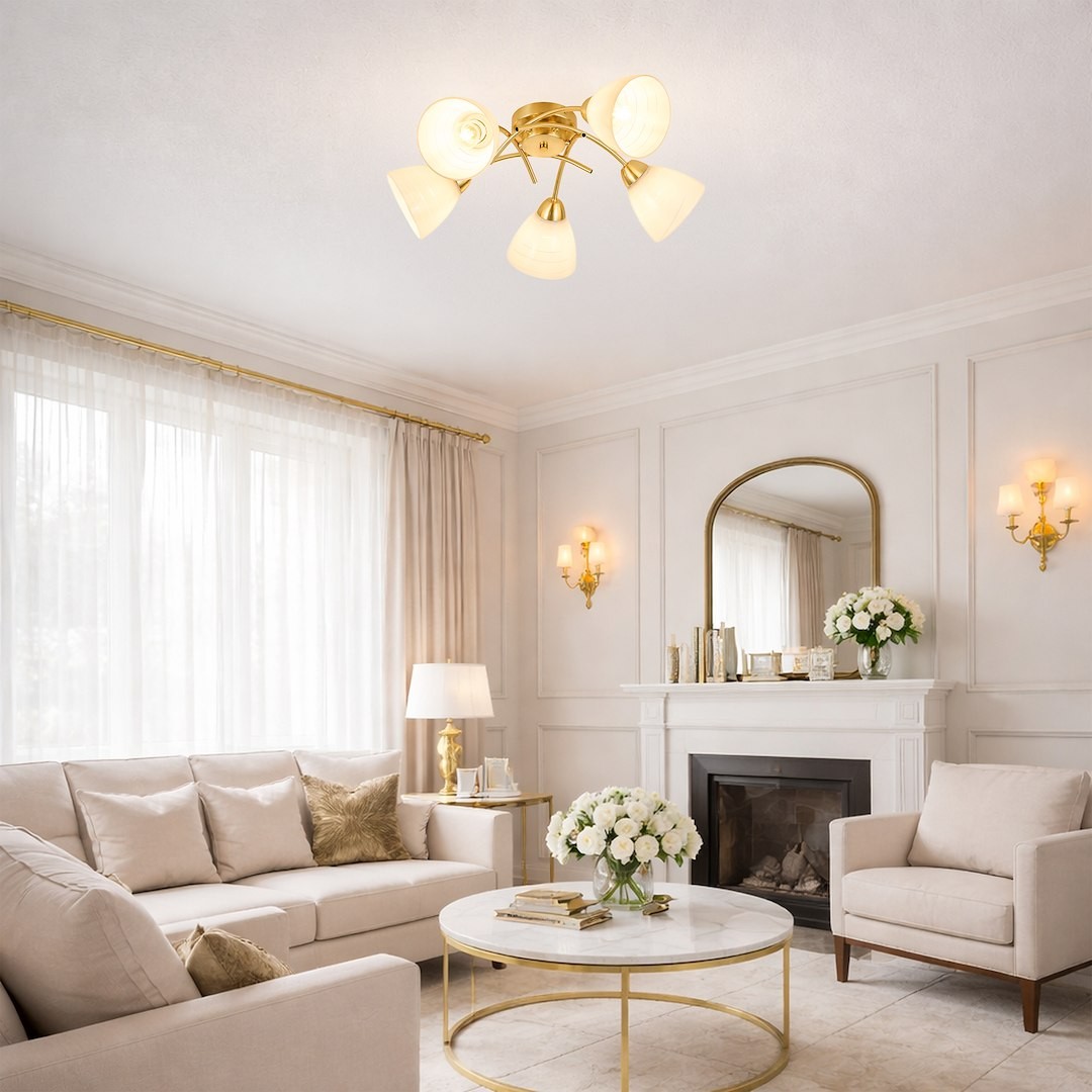 Lampa sufitowa Clara w kolorze złotym, z pięcioma kloszami E27, umieszczona na suficie w jasnym wnętrzu. Klosze mają delikatny, półprzezroczysty design, a lampa jest centralnym punktem aranżacji w salonie z jasnymi meblami.