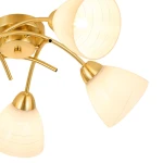 Złota lampa sufitowa Clara z pięcioma kloszami na żarówki E27. Klosze w kształcie stożka, wykonane z mlecznego szkła z delikatnymi liniami. Lampa zamontowana na okrągłej podstawie, z widocznymi metalowymi elementami. Ujęcie z góry.