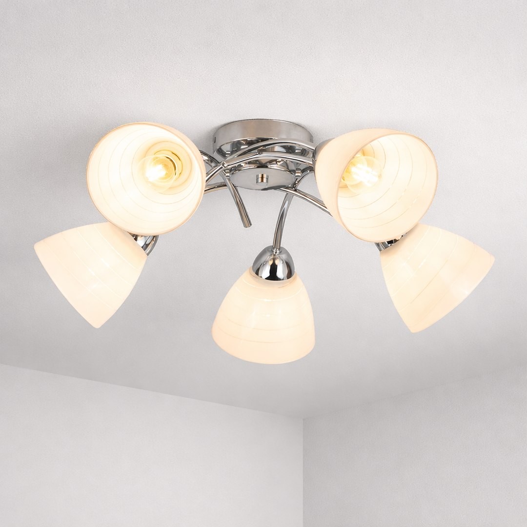Lampa sufitowa Clara z pięcioma kloszami E27 w kolorze chromu. Klosze mają półprzezroczyste, okrągłe kształty z delikatnymi paskami. Produkt zamontowany na okrągłej podstawie, widoczny z góry w jasnym wnętrzu.