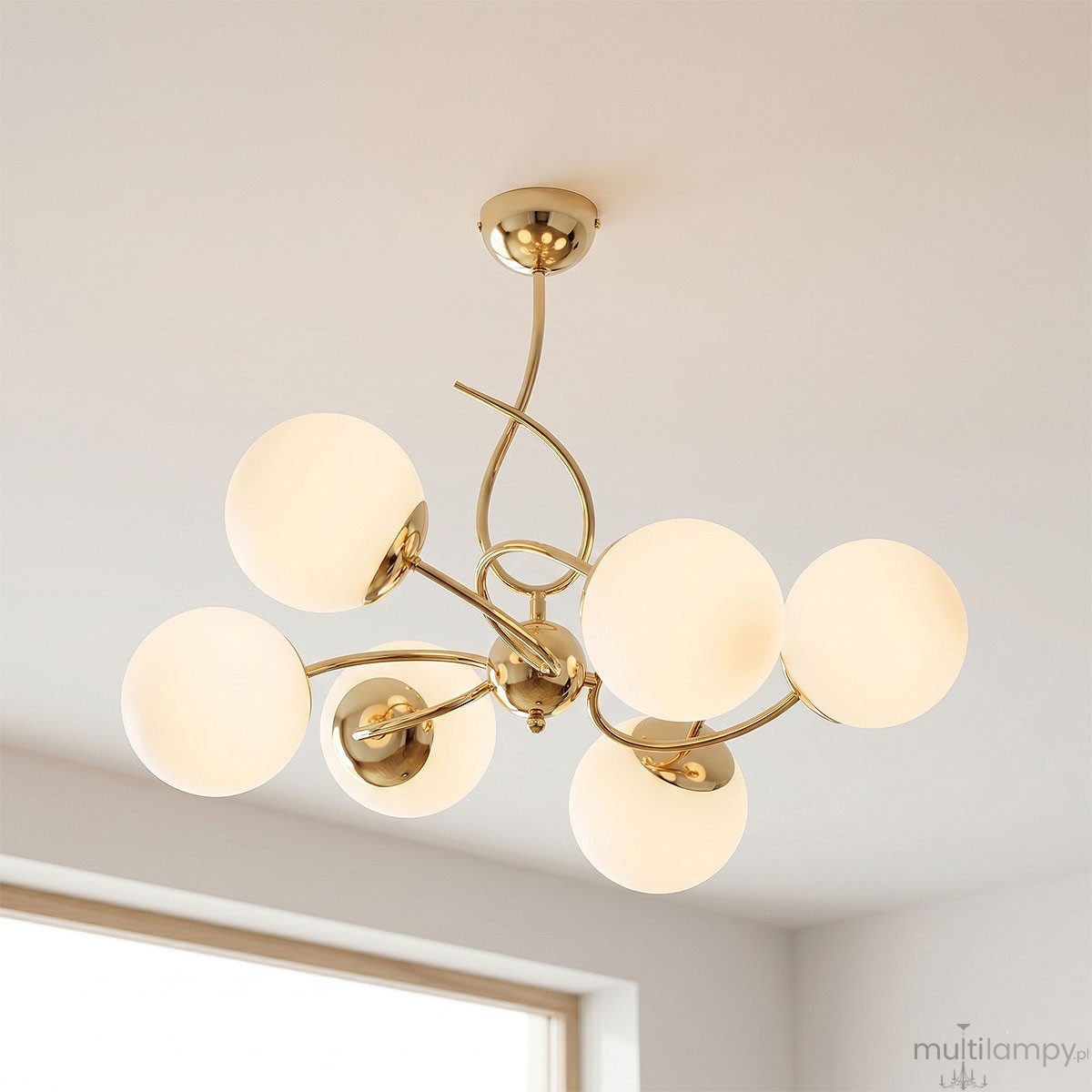 Lampa wisząca Tornado w kolorze złotym z sześcioma kulistymi kloszami z matowego szkła. Produkt zawieszony, z eleganckim, zakrzywionym ramieniem, idealny do nowoczesnych wnętrz. Wymiary i detale montażowe niewidoczne.