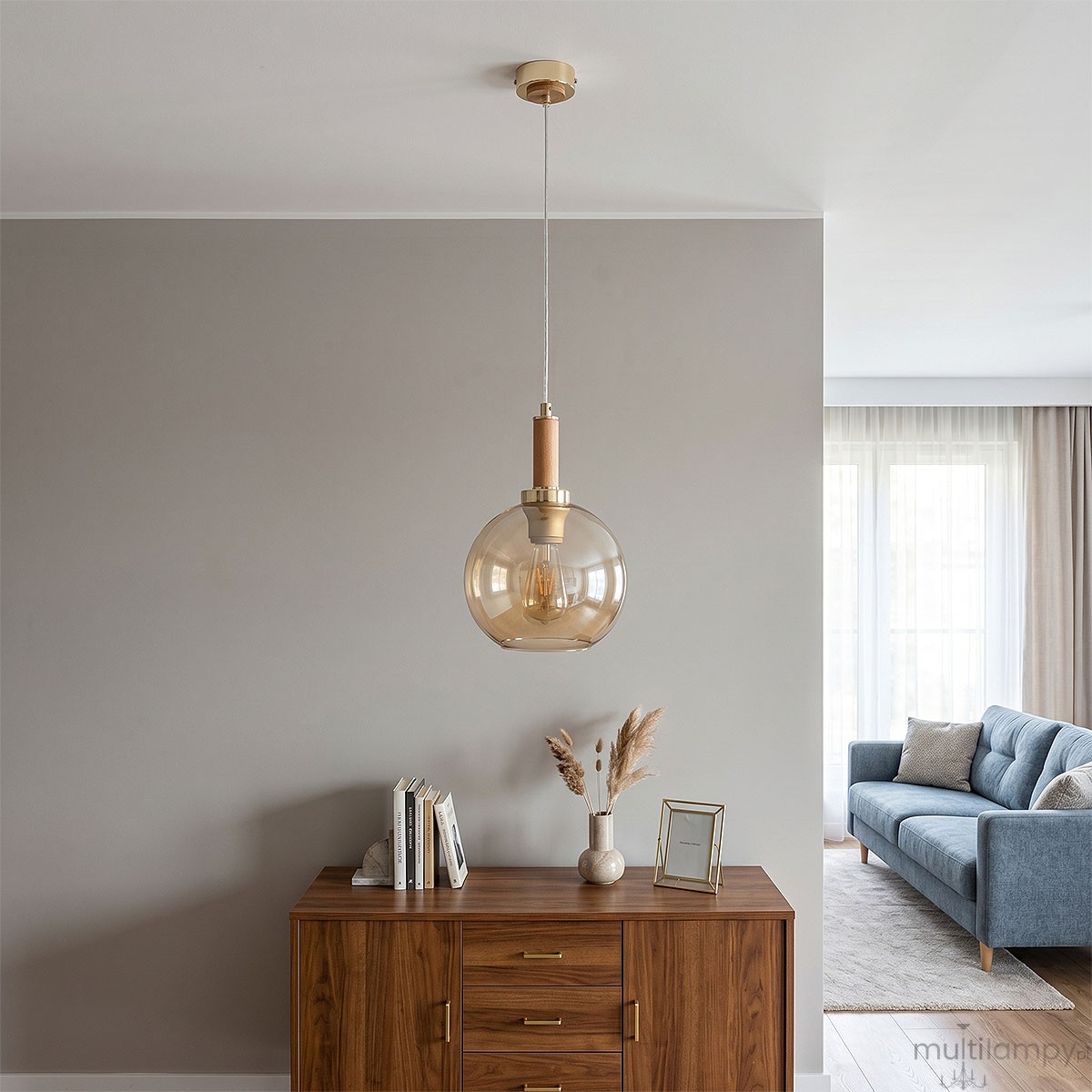 Lampa wisząca Hetty z pojedynczym gniazdem E27, w kolorze złotym i drewnianym. Okrągły klosz ze szkła w odcieniu bursztynowym, zawieszona na przezroczystym przewodzie. Stylowy element oświetleniowy idealny do nowoczesnych wnętrz.