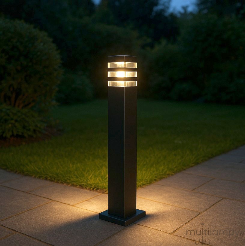 Lampa stojąca Malibu H50 w kolorze czarnym, kwadratowa, o wymiarach 51 cm wysokości i 14 cm podstawy. Górna część z przeźroczystymi elementami, z miejscem na żarówkę E27. Ujęcie z boku, pokazujące proporcje i detale konstrukcji.