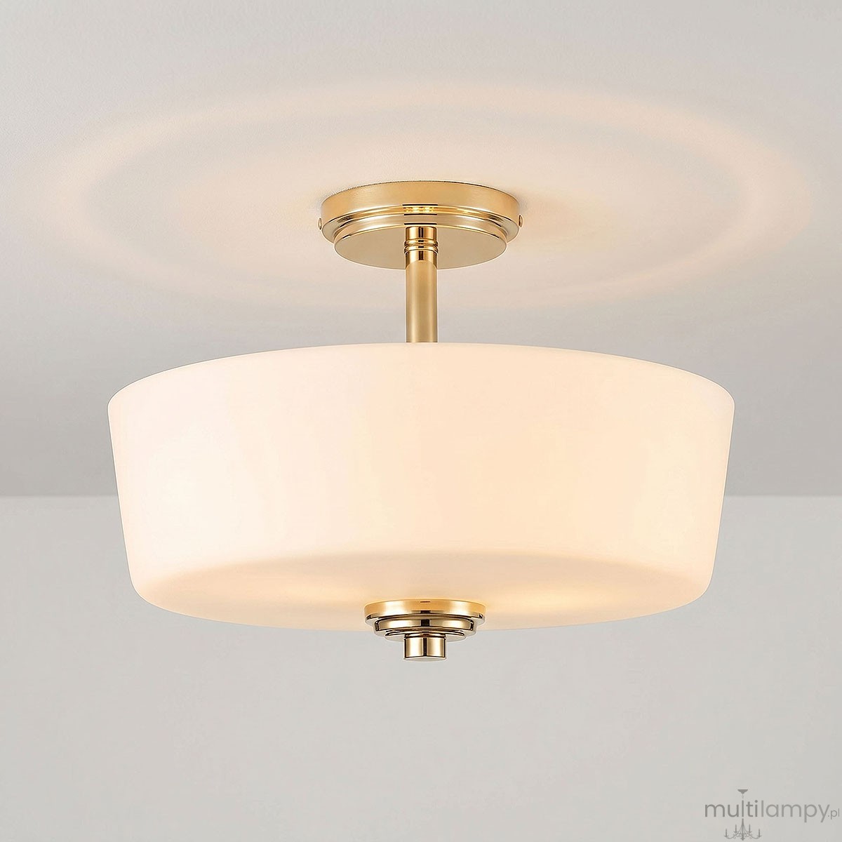 Lampa sufitowa Aspen z trzema gniazdami E27 w kolorze złotym i białym. Okrągły, matowy klosz z białego szkła, zawieszony na złotej podstawie, z delikatnym wykończeniem. Ujęcie z boku, pokazujące detale konstrukcji.