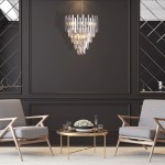 Lampa wisząca Aspen 9-punktowa w chromie, o nowoczesnym, kaskadowym designie z przezroczystymi detalami. Zawieszona na łańcuchu, umieszczona w eleganckim wnętrzu z ciemną ścianą, otoczona drewnianymi fotelami i okrągłym stolikiem.