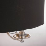 Lampa wisząca Abu Dhabi 5-punktowa, z czarnym abażurem i chromowanymi elementami. Ujęcie w zbliżeniu na dolną część lampy, gdzie widoczny jest metalowy uchwyt. Tło jasne, podkreślające elegancki design produktu.