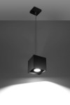 Lampa wisząca Quad 1-punktowa w kolorze czarnym, w formie sześcianu, zawieszona na cienkim przewodzie. Emituje światło z centralnego źródła, na tle szarej ściany, tworzy cień w kształcie prostokąta.
