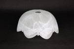 Klosz szklany Fuks D300 w kolorze alabastrowym, o zaokrąglonym kształcie z delikatnymi, falistymi detalami. W górnej części znajduje się okrągłe wycięcie na źródło światła. Produkt leży na czarnym tle, co podkreśla jego transparentność i fakturę.