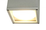 Lampa sufitowa elewacyjna Adela 1-punktowa, wykonana z aluminium w kolorze szarym. Kwadratowa obudowa z widoczną żarówką w środku, montowana w pozycji poziomej. Prosta, minimalistyczna forma, idealna do oświetlenia wnętrza lub elewacji.