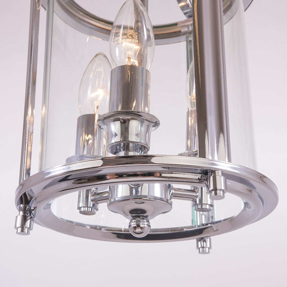 Lampa wisząca New York 3-punktowa z chromowanym wykończeniem, szklanym kloszem i trzema żarówkami w kształcie łzy. Ujęcie z bliska, pokazujące detale mocowania i dekoracyjne elementy.