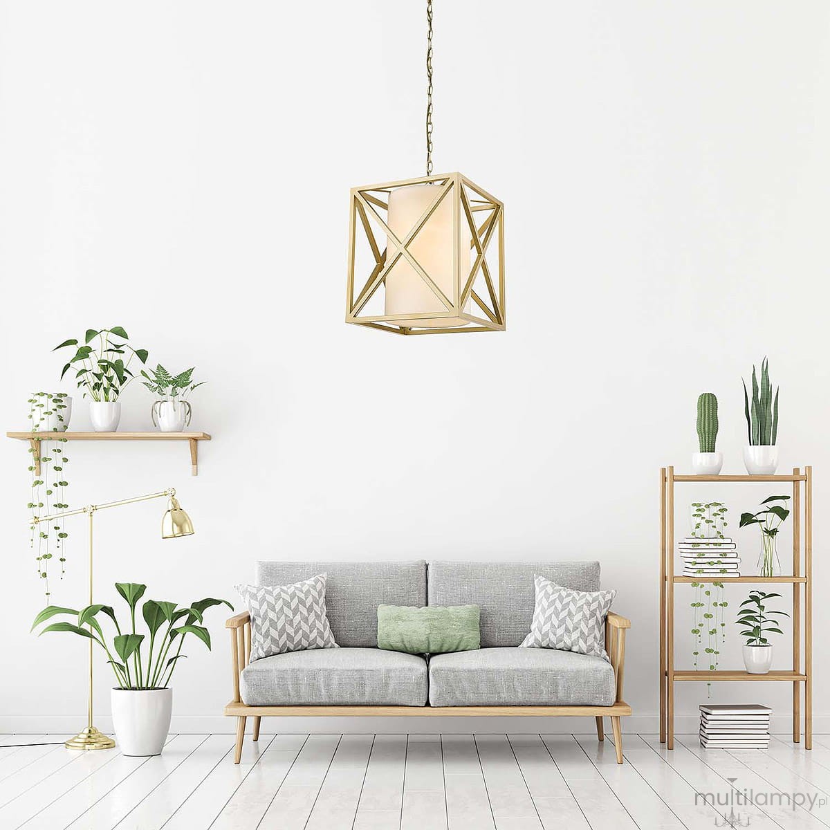 Lampa wisząca New York w geometrze sześcianu, w kolorze złotym, z białym kloszem, zawieszona na łańcuchu. Otoczona roślinami w doniczkach, umieszczona w nowoczesnym wnętrzu z jasnymi ścianami i drewnianymi meblami.
