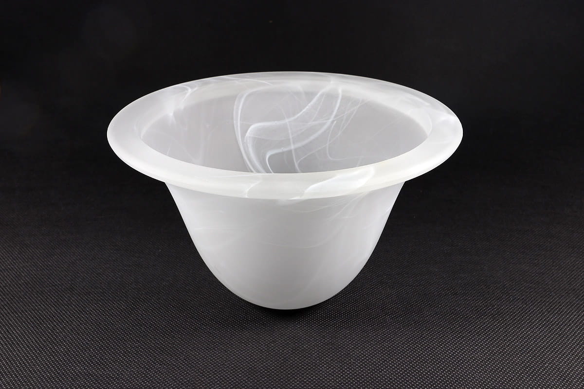 Klosz szklany Dzwonek D175 w kolorze alabastrowym, o zaokrąglonym kształcie i delikatnej, mlecznej fakturze. Ujęcie z boku, ukazujące szeroki brzeg i gładką powierzchnię. Tło ciemne, podkreślające subtelność materiału.