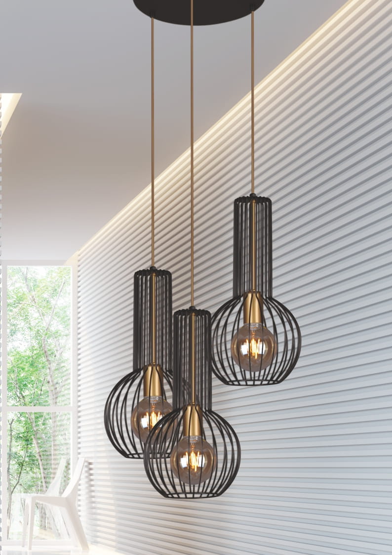 Lampa wisząca Arvi 3-punktowa w kolorze czarnym, z metalowymi kloszami w formie siatki, zawieszona na trzech złotych linkach. Umieszczona w nowoczesnym wnętrzu z białymi i szaro-beżowymi ścianami oraz dużymi oknami.