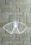 Lampa wisząca Tizi D52 w kolorze białym, o nowoczesnym, ażurowym kształcie, zawieszona na cienkim przewodzie. Widoczny metalowy stelaż w formie otwartej konstrukcji, umieszczony na tle kamiennej ściany.