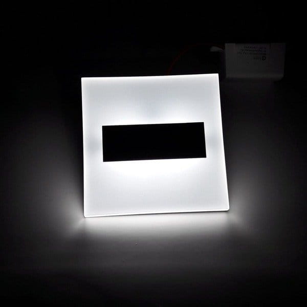 Oprawa schodowa Lumi LED 12V z czujnikiem ruchu, o zimnej barwie światła 6500K. Kwadratowy kształt z białym, matowym wykończeniem i czarnym, prostokątnym wlotem. Widoczna z tyłu jednostka zasilająca.