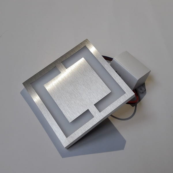 Oprawa schodowa Quadro LED 230V w kształcie kwadratu, z metalową ramką i matowym tworzywem. Barwa zimna 6500K, z widocznym zasilaczem. Ujęcie z góry, ukazujące detale konstrukcji oraz sposoby mocowania.