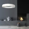 Biała lampa wisząca Reus LED LP-8069/1P w kształcie pierścienia, zawieszona nad minimalistycznym wnętrzem z ciemnym tłem i kominkiem. Prosta konstrukcja, nowoczesny design, idealna do aranżacji przestrzeni.