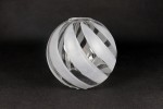 Klosz szklany Zebra II w kształcie kuli o średnicy 145 mm, transparentny z matowymi, spiralnymi zdobieniami. Ujęcie z boku, ukazujące gładką powierzchnię oraz detale wzoru. Tło czarne, co podkreśla elegancję produktu.