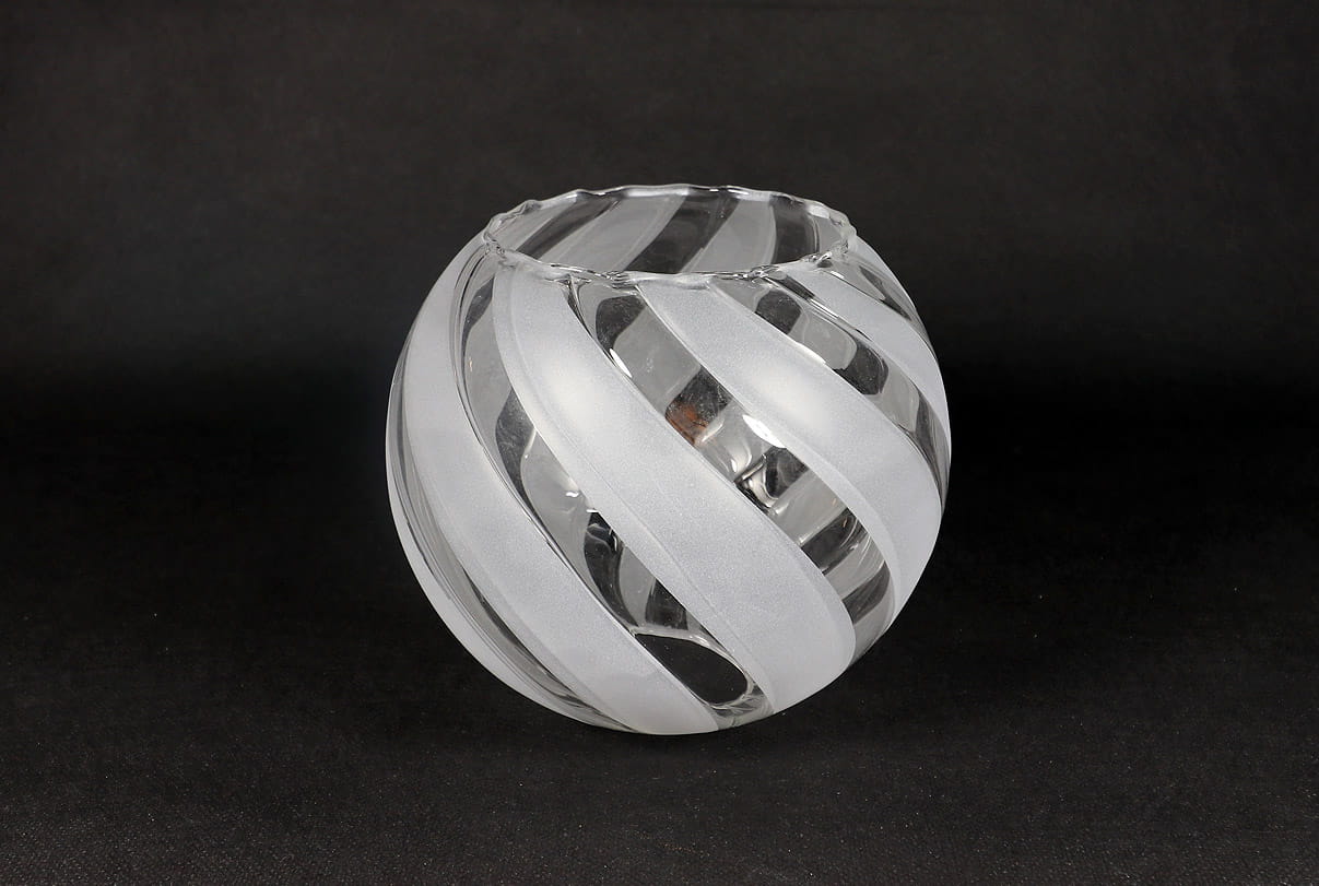 Klosz szklany Zebra II w kształcie kuli o średnicy 145 mm, wykonany z transparentnego i matowego szkła. Posiada spiralny wzór wzdłuż powierzchni, z wyraźnym podziałem na przezroczyste i matowe pasy. Ułożony w pozycji stojącej na czarnym tle.