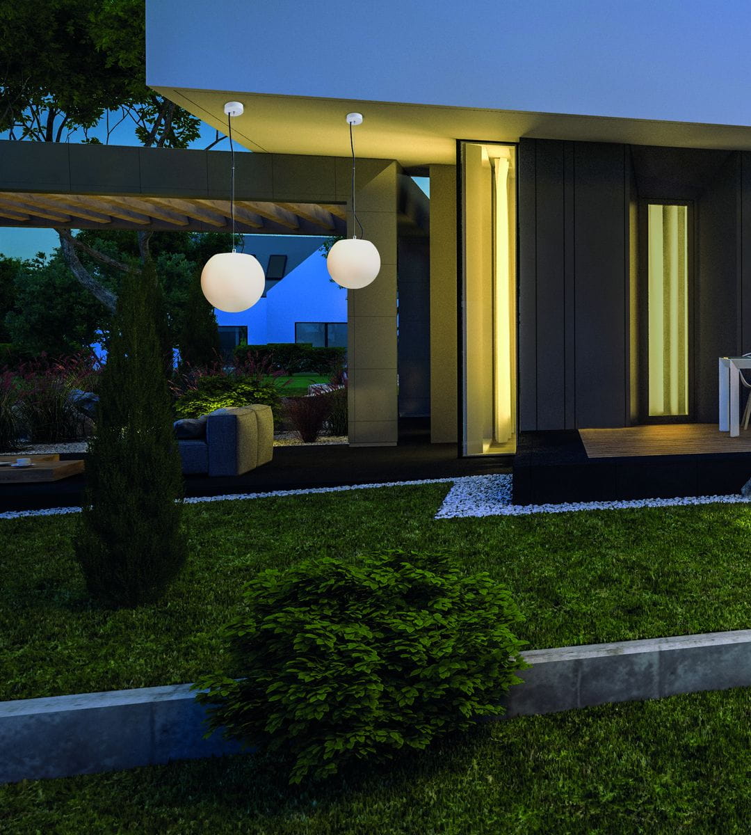 Wisząca lampa ogrodowa Cumulus L, z białym, okrągłym kloszem, zawieszona na cienkim przewodzie. Umieszczona w nowoczesnym otoczeniu, z zielonym trawnikiem i roślinami. W tle widoczny fragment stylowego budynku.