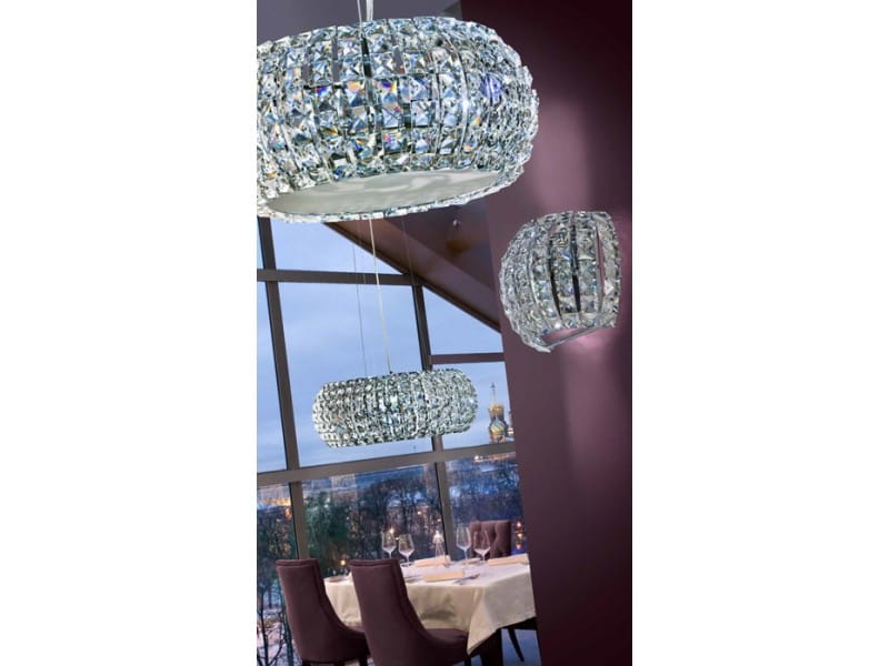 Lampa wisząca Sophia D42, 5-punktowa, w kształcie zaokrąglonego klosza z przezroczystymi kryształkami, zawieszona na długich linkach. Widoczna w eleganckim wnętrzu, w otoczeniu okna i stołu, tworzy efektowne oświetlenie.