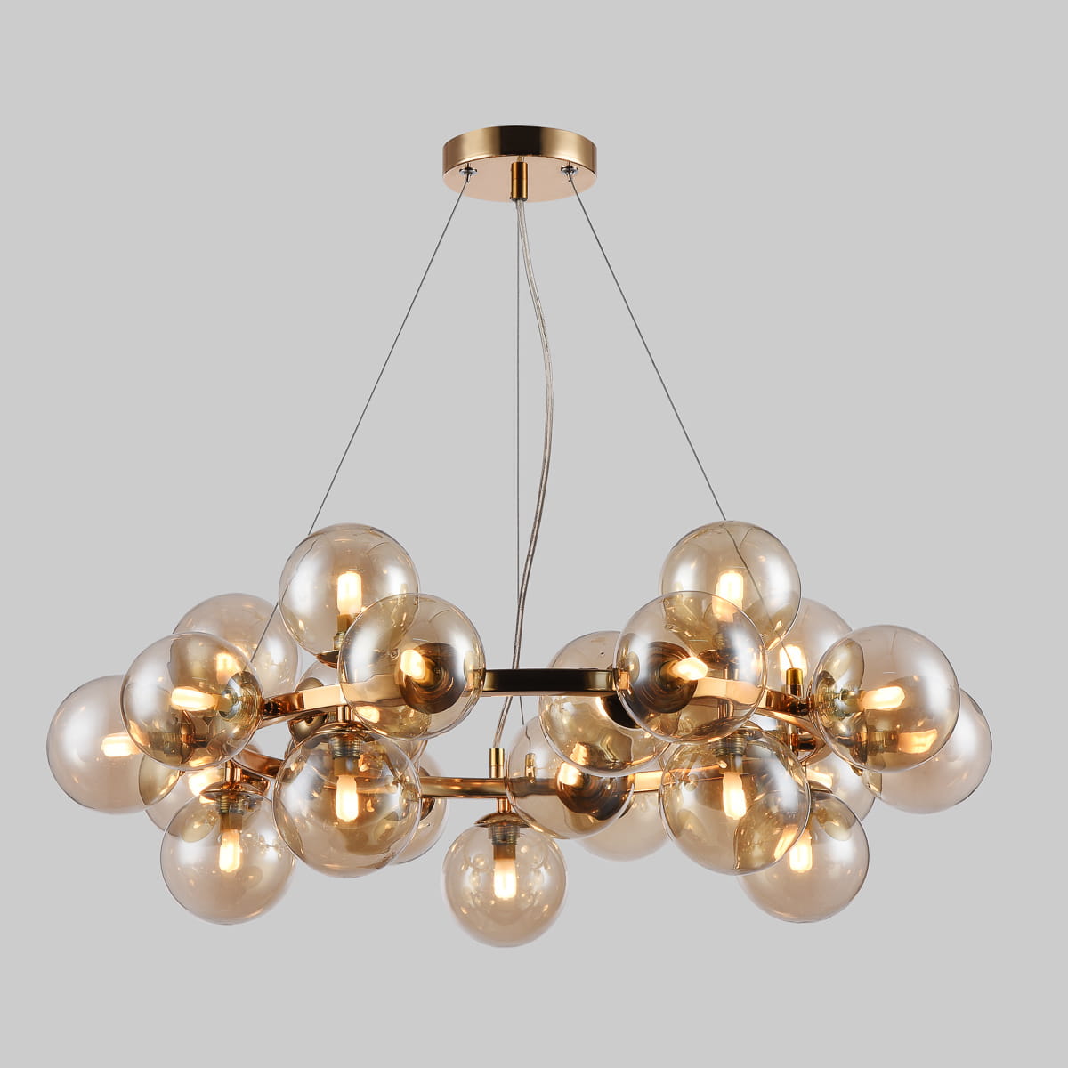 Lampa wisząca Cabella 25-punktowa w kolorze koniakowym, z przezroczystymi szklanymi kulami, zawieszona na cienkich linkach. Metalowa konstrukcja z błyszczącym wykończeniem. Kule rozmieszczone równomiernie, tworzą efektowną kompozycję.
